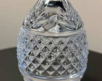 Könnte beinhalten: Ein klares Glasei mit einem Diamantenmuster auf der unteren Hälfte und einem dekorativen Design auf der oberen Hälfte.