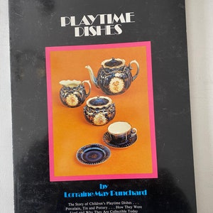 May include: A book titled "Playtime Dishes" by Lorraine May Punchard. The cover features a photograph of a miniature tea set with a teapot, creamer, sugar bowl, cup and saucer, all in a blue and gold floral pattern.