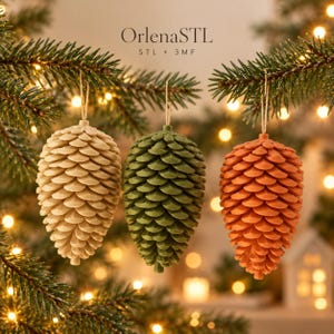 Könnte beinhalten: Drei hängende Tannenzapfen-Ornamente in Beige, Grün und Orange, jeweils an einer dünnen Schnur befestigt. Der Text OrlenaSTL STL + 3MF ist oben in der Mitte sichtbar. Die Ornamente haben ein geschichtetes, strukturiertes Schuppendesign.