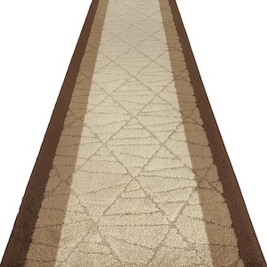 May include: A brown and beige runner rug with a geometric pattern. The rug has a narrow border on each side.