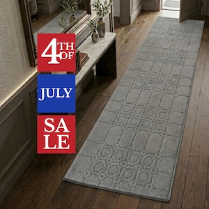 May include: A long, rectangular gray runner rug featuring a repeating geometric pattern of circles and octagons. The rug has a textured, low-pile surface and finished edges. Overlaid text in red and blue boxes reads 4TH OF JULY SALE.