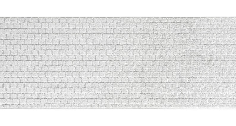 May include: White bath mat with a textured brick pattern.