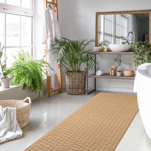 May include: A light brown bath mat with a woven texture, placed in a bathroom with a white bathtub, a wooden shelf with a sink, and plants.