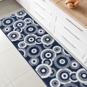May include: A blue and white patterned runner rug with a circular design. The rug is placed in a kitchen setting.
