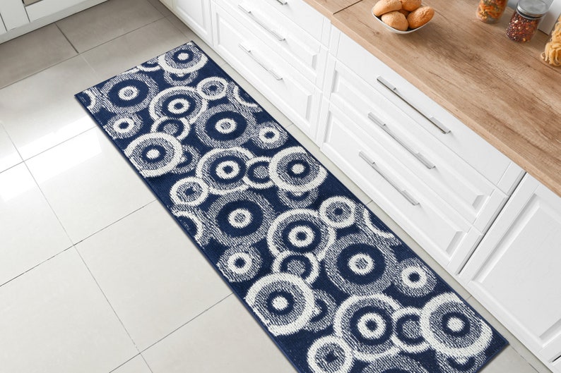 May include: A blue and white patterned runner rug with a circular design. The rug is placed in a kitchen setting.