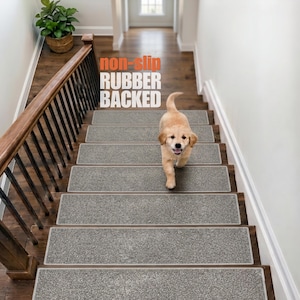 May include: Rectangular grey carpet stair treads with a non-slip rubber backing, installed on wooden stairs. The treads feature a textured, speckled surface. The text "non-slip RUBBER BACKED" is visible in the upper portion of the image.