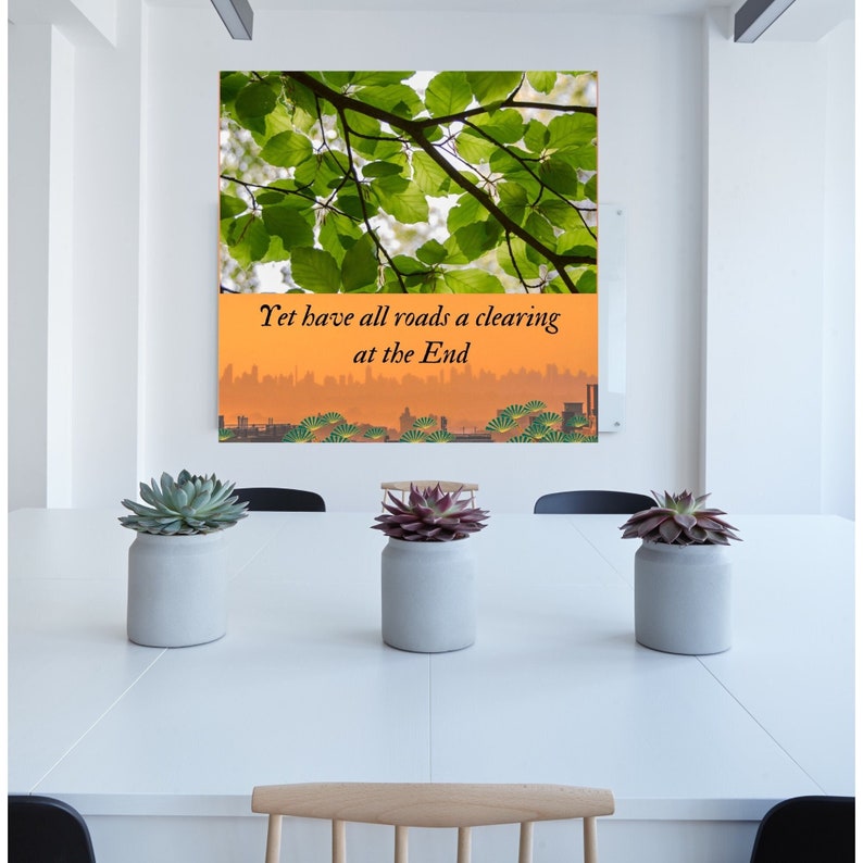 Op de afbeelding: Een motiverend citaat, "Yet have all roads a clearing at the End", wordt weergegeven op een canvas print met een achtergrond van groene bladeren en een stadsbeeld.
