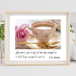 Puede incluir: Una impresión enmarcada que presenta una taza de té rosa y un platillo con diseños florales dorados, llenos de té, y una cuchara dorada. Una rosa rosa está al lado de la taza de té. La cita "You can't get a cup of tea big enough or a book long enough to suit me. C.S. Lewis" está escrita debajo.