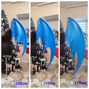 以下が含まれることがあります： 鱗状のテクスチャを持つ発泡スチロール製の青いドラゴンウィング。ウィングはスタンドに表示され、長さは100cm、135cm、170cmです。