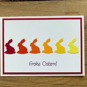 Osterkarte weiß rot gelb orange farbige Osterhasen Gruß Frohe Ostern Karte