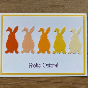 Osterkarte weiß gelb orange farbige Osterhasen Gruß Frohe Ostern Karte