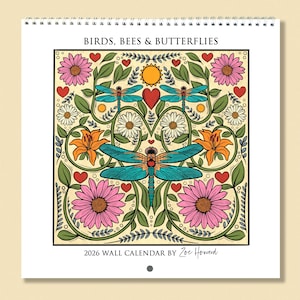 Op de afbeelding: Een 2026 wandkalender met een kleurrijke illustratie van vogels, bijen en vlinders. Het ontwerp bevat libellen, bloemen, harten en een zon. De kalender is van Zoe Howard.
