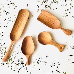 Könnte beinhalten: Vier Holzlöffel in verschiedenen Größen und Formen. Die Löffel sind aus hellem braunem Holz gefertigt und haben eine natürliche Oberfläche. Sie sind auf einem weißen Hintergrund angeordnet.