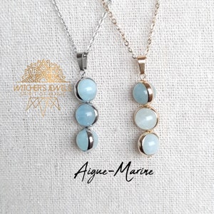 Peut inclure: Deux colliers en pierre d'aigue-marine, chacun avec trois pierres. Le collier de gauche a une chaîne en argent et le collier de droite a une chaîne en or. Le texte "Aigue-Marine" est écrit sous les colliers.