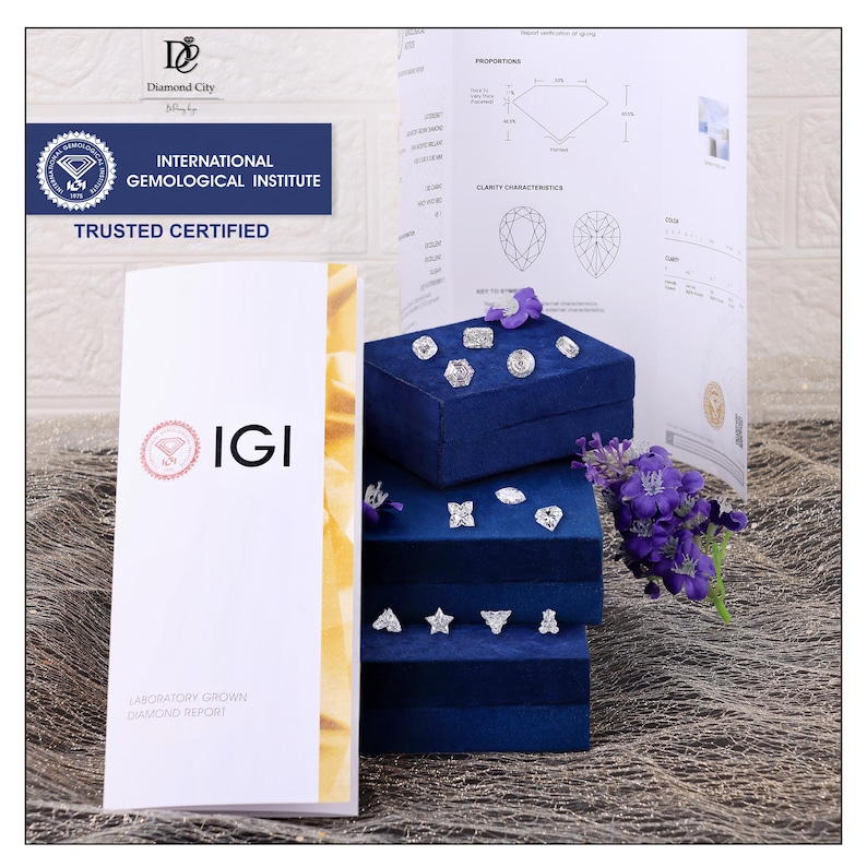 May include: A collection of loose, faceted, clear gemstones in various shapes including star, heart, and geometric cuts, displayed on stacked blue velvet boxes. An IGI laboratory grown diamond report document is positioned next to the jewellery display.