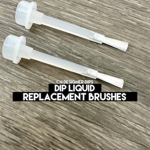 May include: Two clear plastic dip liquid replacement brushes with white bristles. The brushes have a cap and are labeled "CN DESIGNER DIPS DIP LIQUID REPLACEMENT BRUSHES."