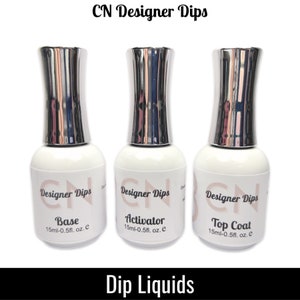 May include: Three bottles of nail dip liquids labeled "CN Designer Dips" with the words "Base", "Activator", and "Top Coat" on each bottle. Each bottle contains 0.5 fl. oz. of liquid.