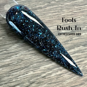 以下が含まれることがあります： CN Designer Dipsの「Fools Rush In」という名前の、黒と青のグリッター入りネイルディップです。