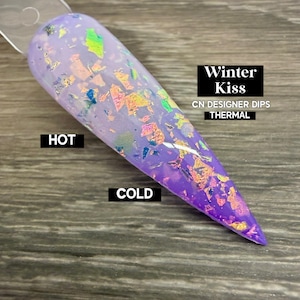 以下が含まれることがあります： 薄紫から濃い紫へと変化するグラデーション効果のあるネイルサンプル。 虹色のフレークが飾られています。 画像のテキストは「Winter Kiss」、「CN DESIGNER DIPS THERMAL」、「HOT」、「COLD」です。