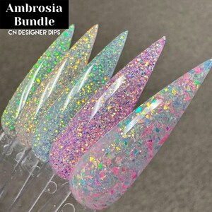 Puede incluir: Ambrosia Bundle CN Designer Dips. Cinco colores de polvo de inmersi&oacute;n para u&ntilde;as en frascos transparentes con una variedad de acabados de purpurina iridiscente. Los colores incluyen un azul claro, un rosa claro, un transparente con purpurina iridiscente y dos colores m&aacute;s con purpurina iridiscente.