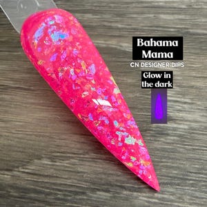 May include: A pointed nail swatch stick featuring a vibrant hot pink base color embedded with iridescent, multi-colored foil flakes. The text reads Bahama Mama, CN DESIGNER DIPS, and Glow in the dark, accompanied by a small graphic of a glowing nail.