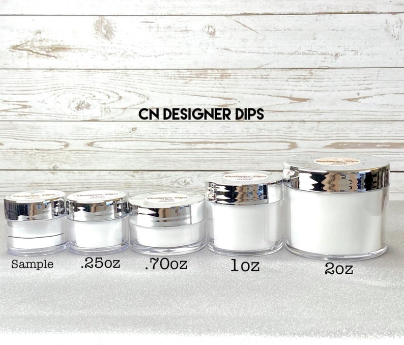 May include: Five clear acrylic jars with silver lids, labeled "Sample", ".25oz", ".70oz", "1oz", and "2oz". The jars are filled with a white substance. The text "CN DESIGNER DIPS" is printed at the top.