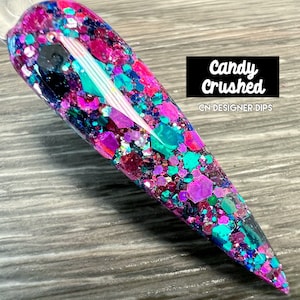 Puede incluir: Primer plano de una uña larga y transparente con un acabado brillante. La purpurina es una mezcla de rosa, morado, azul y verde. El texto "Candy Crushed" y "CN Designer Dips" es visible en la imagen.