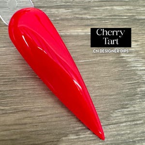 May include: A bright red nail dip powder called "Cherry Tart" by CN Designer Dips.