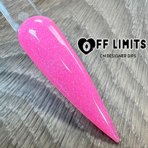 Puede incluir: Un polvo de inmersión para uñas de color rosa con purpurina, con un corazón y el texto "OFF LIMITS CN DESIGNER DIPS".
