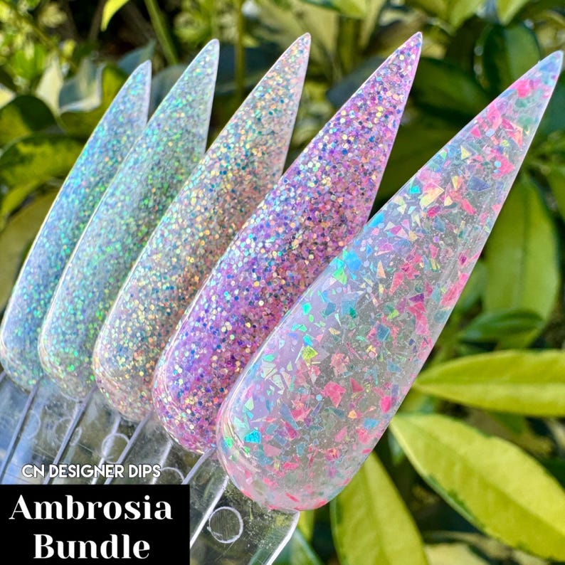 Puede incluir: Un conjunto de cuatro polvos para u&ntilde;as en varios tonos de rosa y blanco con purpurina y escamas iridiscentes. Los polvos est&aacute;n etiquetados como "Ambrosia Bundle" y "CN Designer Dips".