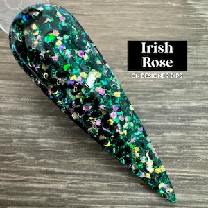 May include: A close-up of a green glitter nail dip powder with gold and iridescent glitter. The text "Irish Rose" and "CN Designer Dips" is visible in the image.