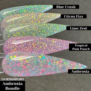 Puede incluir: Cinco botellas transparentes de polvo de inmersi&oacute;n para u&ntilde;as con purpurina iridiscente. Las botellas est&aacute;n etiquetadas con los nombres "Blue Crush", "Citrus Fizz", "Lime Zest", "Tropical Pink Punch" y "Ambrosia". El texto "CN DESIGNER DIPS Ambrosia Bundle" est&aacute; en la parte inferior de la imagen.