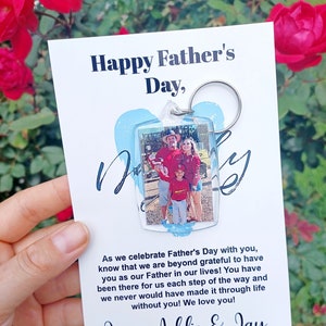 May include: A white card with a blue and white heart-shaped keychain attached. The keychain has a photo of a family of four. The card reads "Happy Father's Day" and "Love, Addie & Jay".