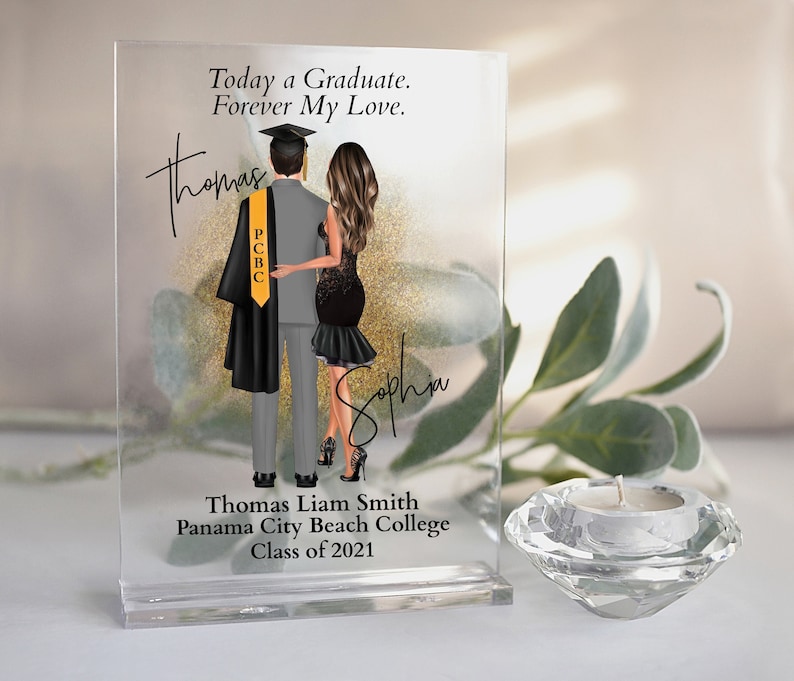 May include: A glass block with a photo of a couple, a graduate in a cap and gown and a woman in a black dress. The text "Today a Graduate. Forever My Love." is at the top of the block. The text "Thomas Liam Smith Panama City Beach College Class of 2021" is at the bottom of the block.