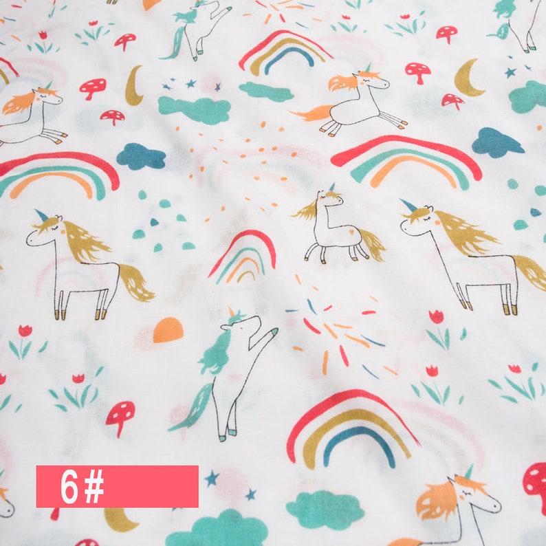 May include: White fabric with a repeating pattern of colourful rainbows, stars, clouds, mushrooms, and unicorns. The text "6#" is printed in red at the bottom of the image.