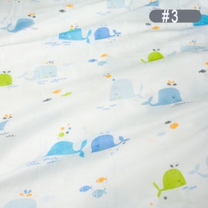 May include: White fabric with a repeating pattern of blue and green whales, orange and blue fish, and white stars. The fabric has the number #3 printed in the top right corner.