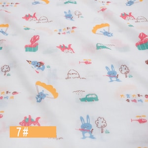 May include: White fabric with a repeating pattern of colourful cartoon bunnies, helicopters, cars, and other whimsical illustrations. The text "大吉大利今晚吃鸡" is repeated throughout the fabric. The number "7#" is written in orange at the bottom of the image.