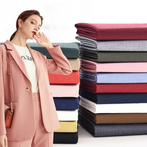 Puede incluir: Una pila de muestras de tela en varios colores, incluyendo rojo, rosa, azul, verde y marrón. La tela es lisa y parece ser un material tejido.