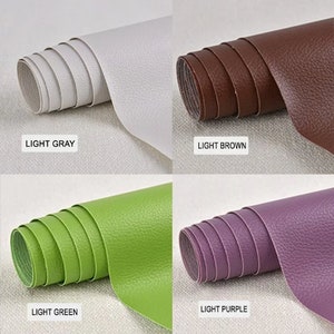 May include: Four rolls of faux leather in different colors: light gray, light brown, light green, and light purple. Each roll is made of a textured material that resembles leather.