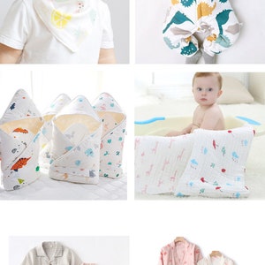 May include: A set of baby clothes and accessories, including a white onesie with a dinosaur print, a white swaddle blanket with a dinosaur print, a white hooded towel with a dinosaur print, a white bib with a lemon print, a white and pink checked pyjama set, and a pink and white floral dressing gown.