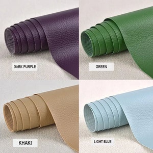 May include: Four rolls of faux leather in different colors: dark purple, green, khaki, and light blue. The leather has a textured surface.