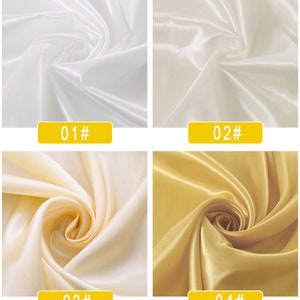 May include: Four fabric swatches in different colours. The swatches are arranged in a grid, with the top left swatch being white, the top right swatch being off-white, the bottom left swatch being a light cream colour, and the bottom right swatch being a gold colour. Each swatch is labelled with a number and a hash symbol.