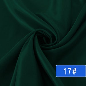 May include: A deep green fabric with a smooth, silky texture. The fabric is folded and draped, showcasing its luxurious feel. The image includes the number "17#" in a blue box.