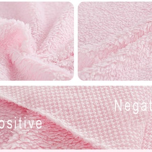 May include: Close-up of a pink fabric with two different textures. The top half of the image shows a fluffy, soft texture, while the bottom half shows a smooth, woven texture. The words "Positive" and "Negative" are printed on the fabric.