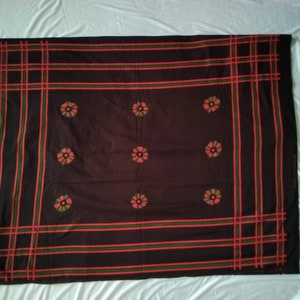 May include: Black fabric with a red and green checkered border and red flower designs throughout.