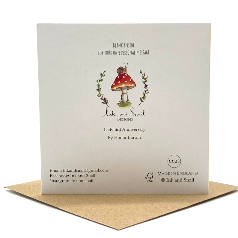 May include: A white card with a red and white mushroom illustration and a snail on top. The card says "Ink and Snail Designs" and "Ladybird Anniversary" with the text "By Honor Barton" below. The card is made in England and is blank inside for a personal message.