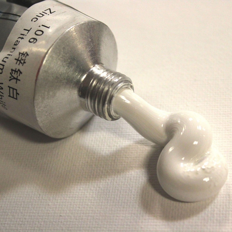 May include: A tube of white paint with the label "106 Titanium White" and "Zinc" in English and Japanese. The paint is being squeezed out of the tube, forming a white blob.
