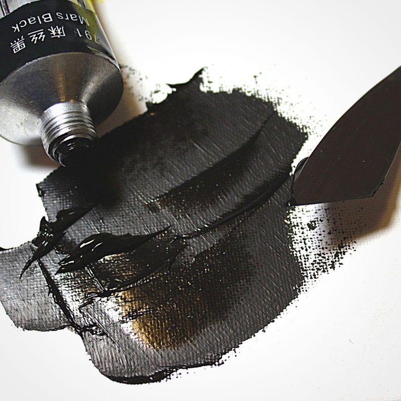 May include: A tube of black acrylic paint with the text "Mars Black 961 芳  墨" on the side. The paint is being squeezed out onto a white surface with a black palette knife.
