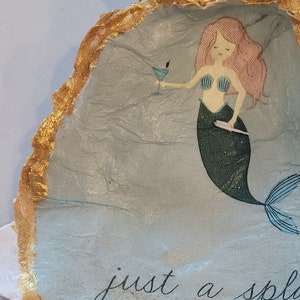 Mermaid oyster shell holding martini