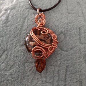 Lovely brown and copper sparkling lampwork glass focal bead hand wrapped in woven copper wire, accented with small glass leaf (with cord)